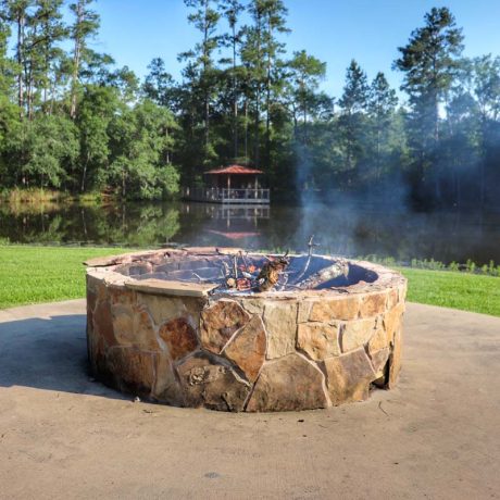 fire pit in front of lake and trees